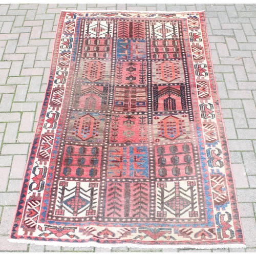 211 - A large vintage Bakhtiari rug of red ground, with decorative squared panels, approx 240cm x 140cm