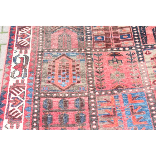 211 - A large vintage Bakhtiari rug of red ground, with decorative squared panels, approx 240cm x 140cm