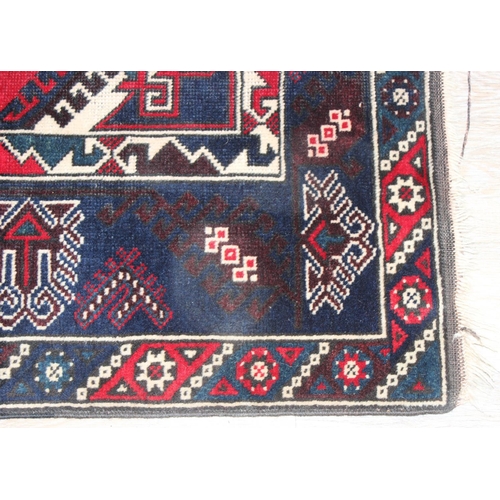 203 - A vintage Turkish rug of red and dark blue ground, believed to be a Yoruk Dosemealti, approx 215cm x... 