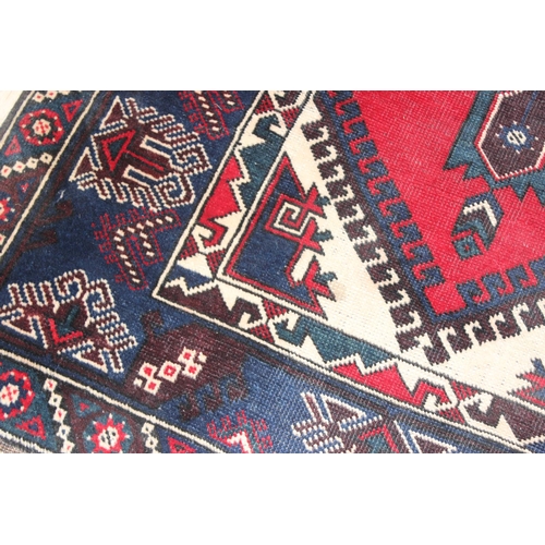 203 - A vintage Turkish rug of red and dark blue ground, believed to be a Yoruk Dosemealti, approx 215cm x... 