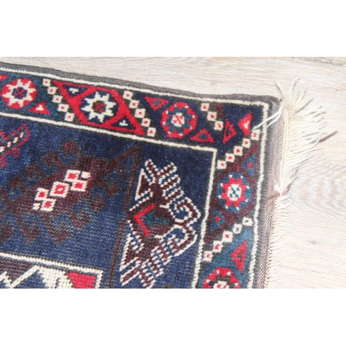 203 - A vintage Turkish rug of red and dark blue ground, believed to be a Yoruk Dosemealti, approx 215cm x... 