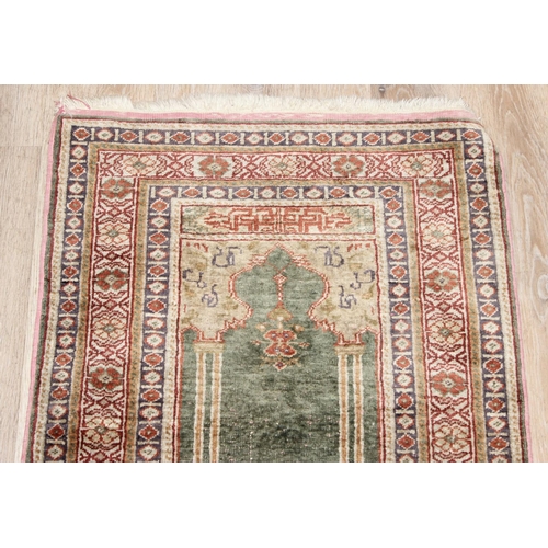 205 - A vintage Turkish prayer rug of faded blue ground, believed to be a silk Kayseri rug, approx 110cm x... 