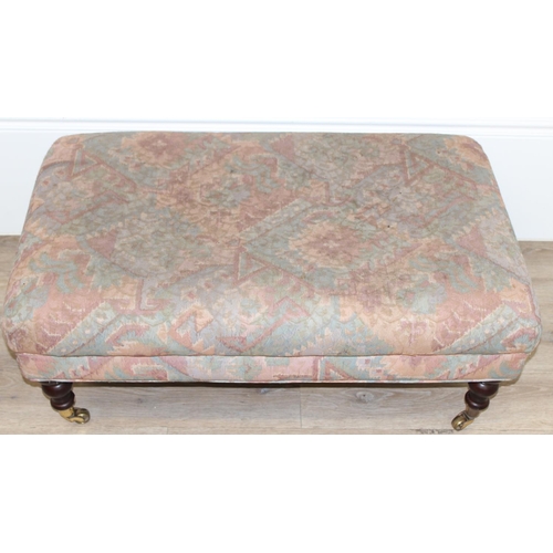 89 - An antique style ottoman or footstool with turned wooden legs and brass castors, approx 95cm wide x ... 