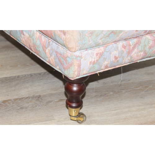 89 - An antique style ottoman or footstool with turned wooden legs and brass castors, approx 95cm wide x ... 