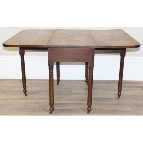 119 - An antique mahogany drop leaf table with turned legs and brass and ceramic castors, approx 100cm wid... 