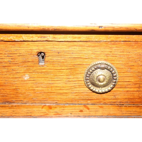 82 - An antique oak 9 drawer pedestal desk with green inset leather top and brass ring handles, early 20t... 