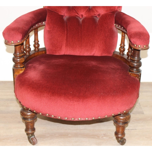 86 - A 19th century red button backed low armchair or library chair with turned wooden legs and scroll ba... 