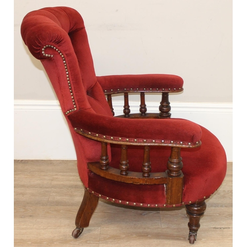 86 - A 19th century red button backed low armchair or library chair with turned wooden legs and scroll ba... 