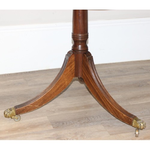 51 - An antique style mahogany twin pedestal dining table with extensions and brass lion paw castors, app... 