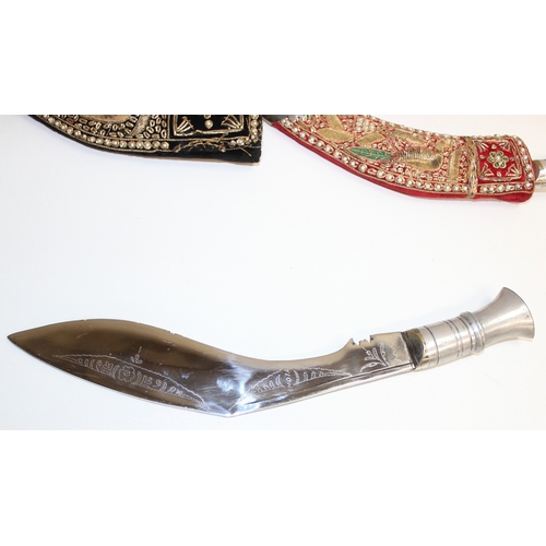 1411 - 2 alloy-hilted Kukri knives, 1 with jewelled-red velvet scabbard, the other longer and with jewelled... 