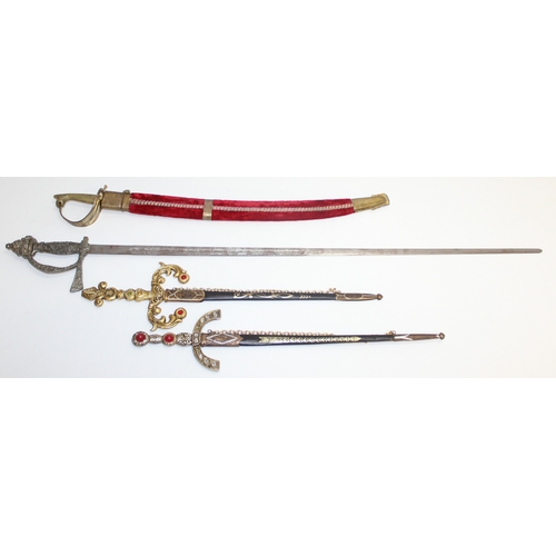 1413 - An Indian brass-hilted sword in red velvet scabbard, two Spanish tourist type large and small decora... 