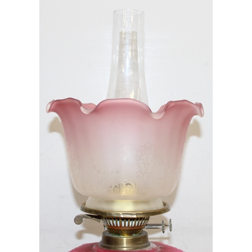 232 - An antique oil lamp with acid etched shade, a moulded pink glass reservoir, brass column and black b... 