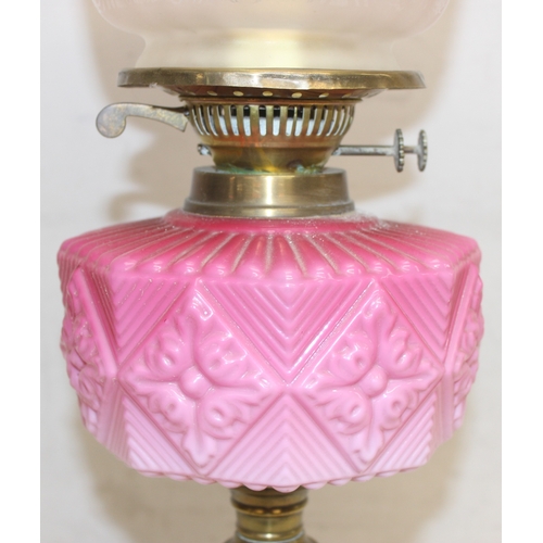 232 - An antique oil lamp with acid etched shade, a moulded pink glass reservoir, brass column and black b... 