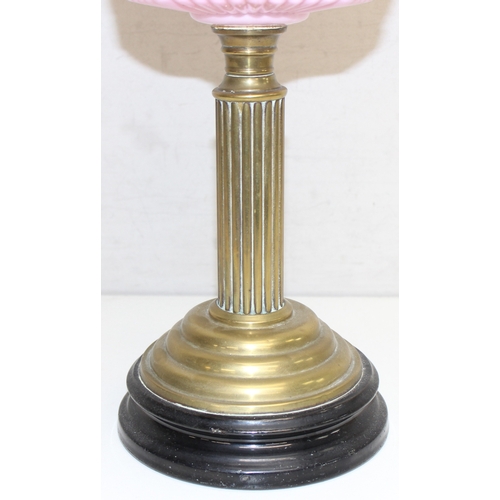 232 - An antique oil lamp with acid etched shade, a moulded pink glass reservoir, brass column and black b... 