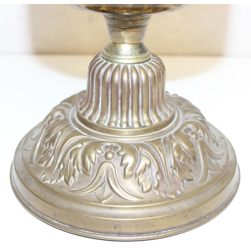 234 - An antique oil lamp with moulded milk glass shade, a glass reservoir, and an embossed brass base, ma... 