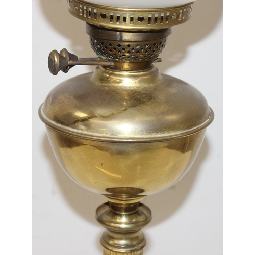 235 - An antique oil lamp with acid etched Art Nouveau glass shade, a brass reservoir, brass column, and a... 