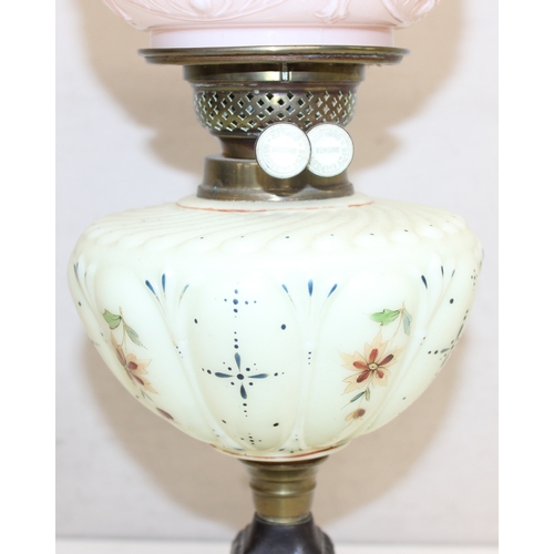 236 - An antique oil lamp with moulded milk glass shade, a moulded and painted milk glass reservoir, and a... 