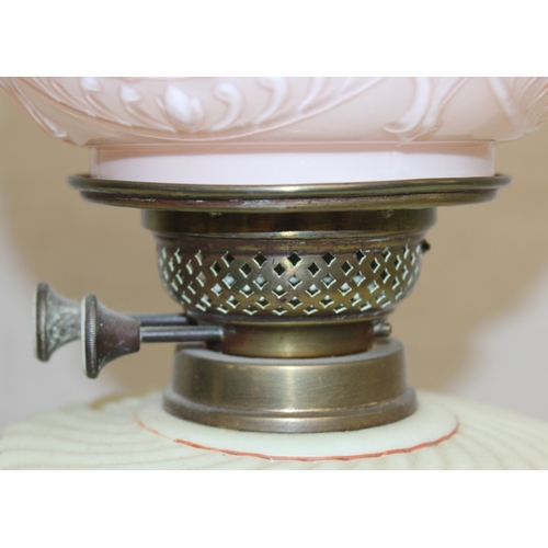 236 - An antique oil lamp with moulded milk glass shade, a moulded and painted milk glass reservoir, and a... 