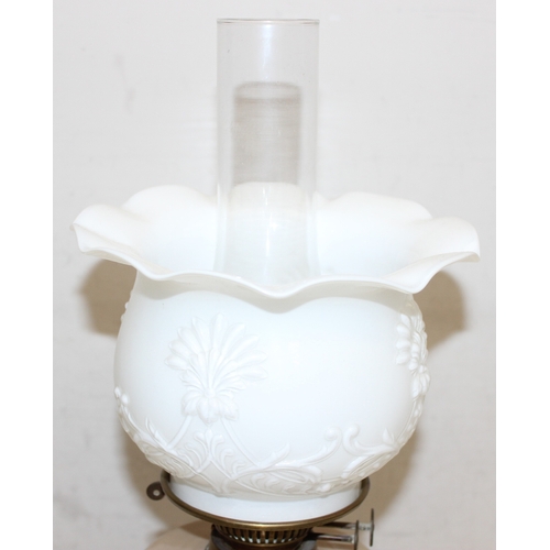 237 - An antique oil lamp with moulded milk glass shade, a painted caramel coloured glass reservoir, and a... 