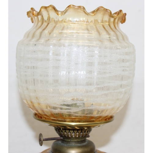 239 - An antique oil lamp with decorative glass shade, an amber coloured glass reservoir, and a cast iron ... 