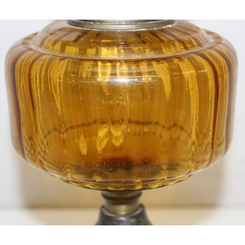 239 - An antique oil lamp with decorative glass shade, an amber coloured glass reservoir, and a cast iron ... 