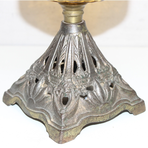 239 - An antique oil lamp with decorative glass shade, an amber coloured glass reservoir, and a cast iron ... 