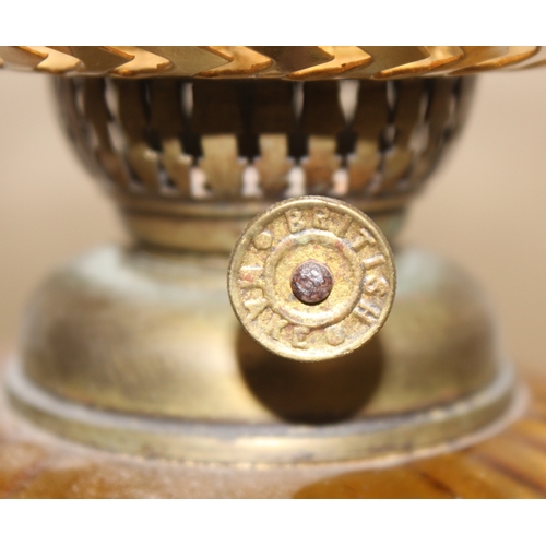 239 - An antique oil lamp with decorative glass shade, an amber coloured glass reservoir, and a cast iron ... 