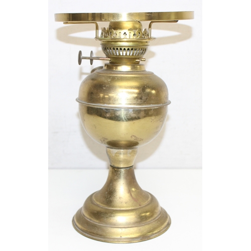 239 - An antique oil lamp with decorative glass shade, an amber coloured glass reservoir, and a cast iron ... 