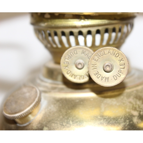 239 - An antique oil lamp with decorative glass shade, an amber coloured glass reservoir, and a cast iron ... 