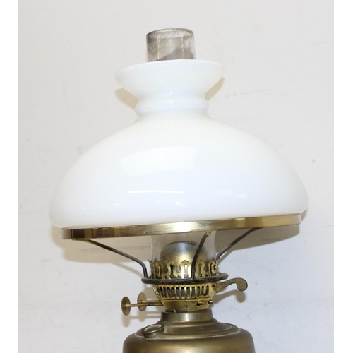 252 - An antique gilt metal oil lamp with black glazed pottery base, white glass shade and glass chimney, ... 