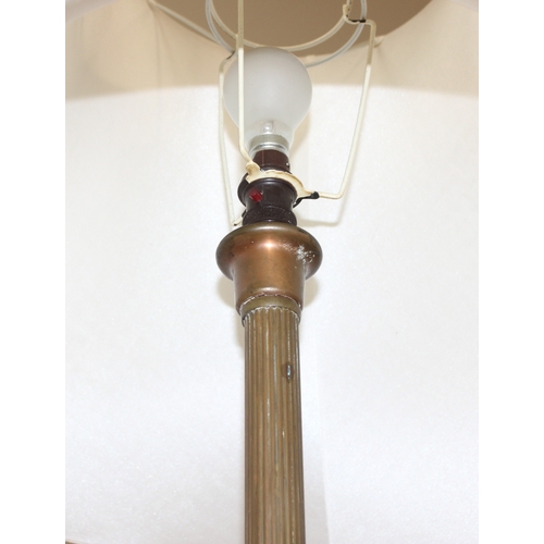 243 - A vintage brass standard lamp with shade, the lamp formed as a reeded pillar, approx 185cm tall