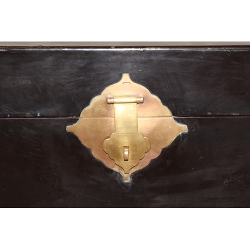 283 - A vintage Oriental black lacquered box with embossed brass fittings, approx 62cm wide x 40cm deep x ... 