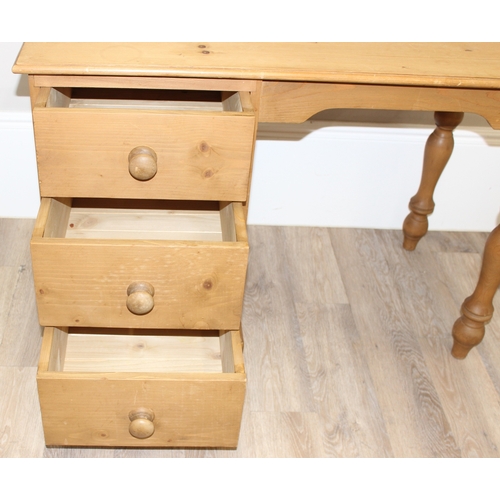 79 - A modern stripped pine desk with 3 drawers, approx 110cm wide x 57cm deep x 77cm tall