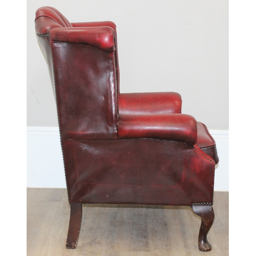 80 - An Ox-Blood red leather Chesterfield style wingback armchair by Wyvern, approx 82cm wide x 100cm tal... 