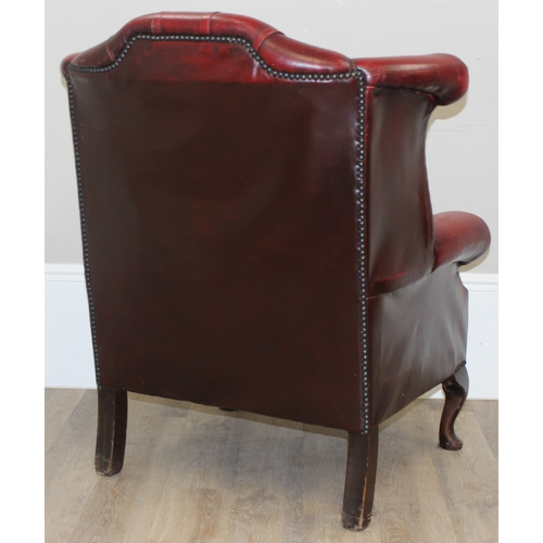 80 - An Ox-Blood red leather Chesterfield style wingback armchair by Wyvern, approx 82cm wide x 100cm tal... 