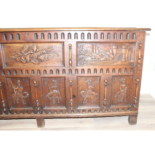 34 - An impressive antique oak coffer with carved details, the body of unusual large proportions with peg... 