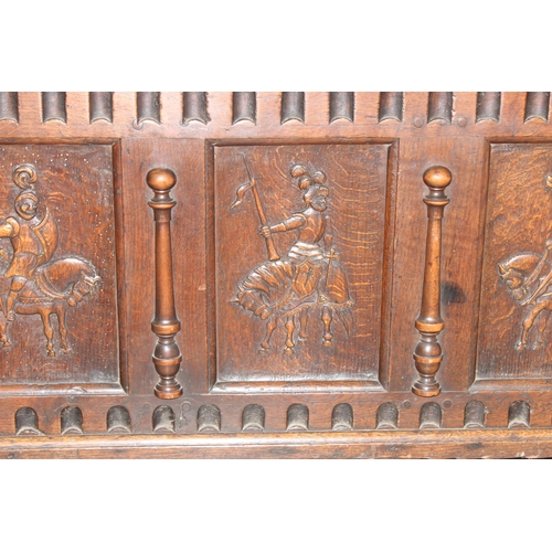 34 - An impressive antique oak coffer with carved details, the body of unusual large proportions with peg... 