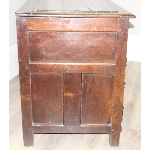 34 - An impressive antique oak coffer with carved details, the body of unusual large proportions with peg... 