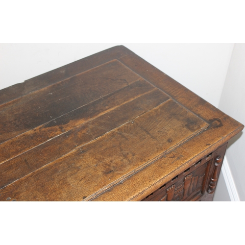 34 - An impressive antique oak coffer with carved details, the body of unusual large proportions with peg... 