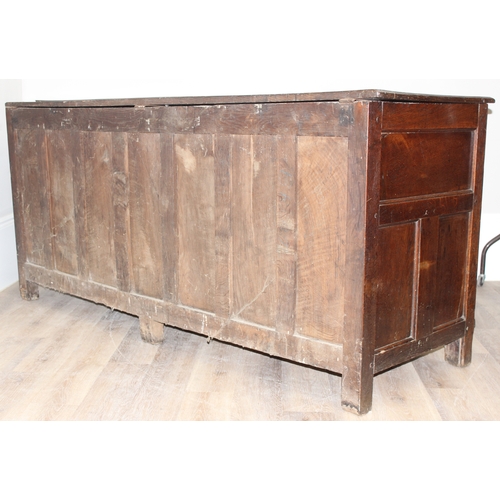 34 - An impressive antique oak coffer with carved details, the body of unusual large proportions with peg... 