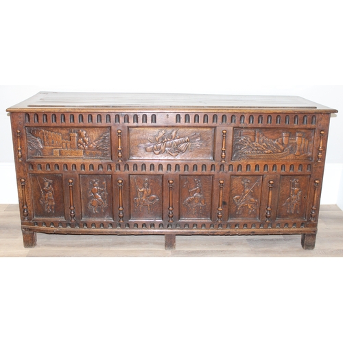 34 - An impressive antique oak coffer with carved details, the body of unusual large proportions with peg... 