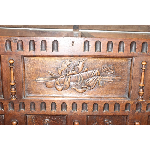 34 - An impressive antique oak coffer with carved details, the body of unusual large proportions with peg... 