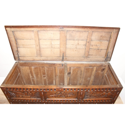 34 - An impressive antique oak coffer with carved details, the body of unusual large proportions with peg... 