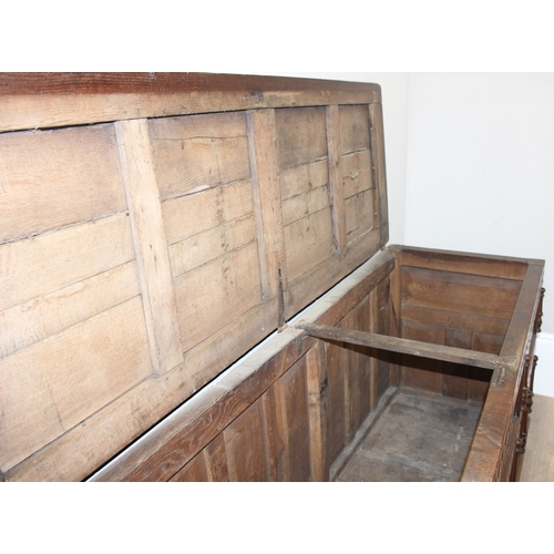 34 - An impressive antique oak coffer with carved details, the body of unusual large proportions with peg... 