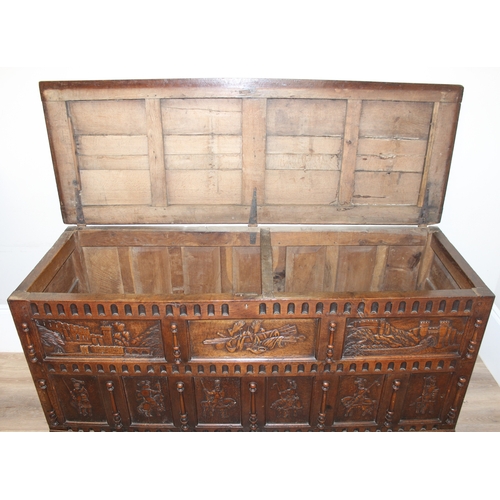 34 - An impressive antique oak coffer with carved details, the body of unusual large proportions with peg... 