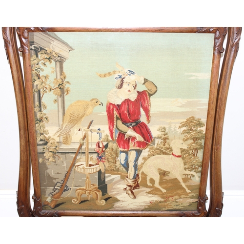 32 - An impressive Victorian fire screen with carved mahogany frame, the revolving centre showing a tapes... 