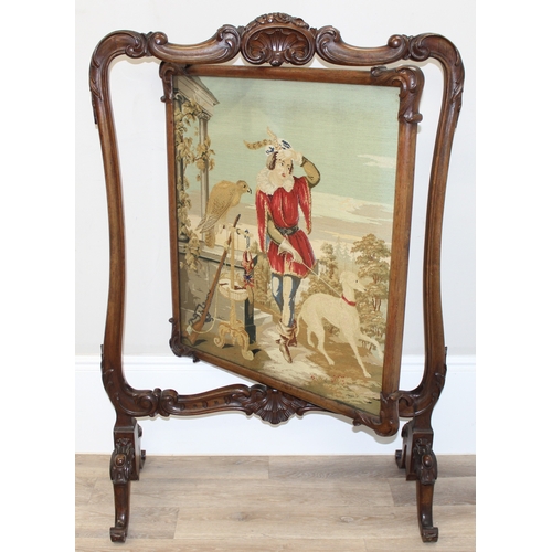 32 - An impressive Victorian fire screen with carved mahogany frame, the revolving centre showing a tapes... 