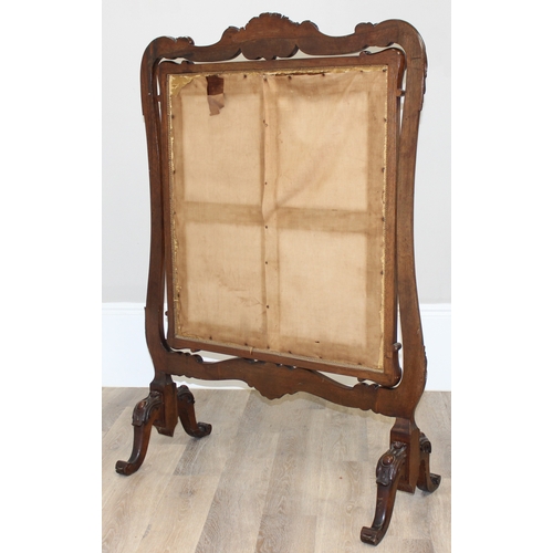 32 - An impressive Victorian fire screen with carved mahogany frame, the revolving centre showing a tapes... 