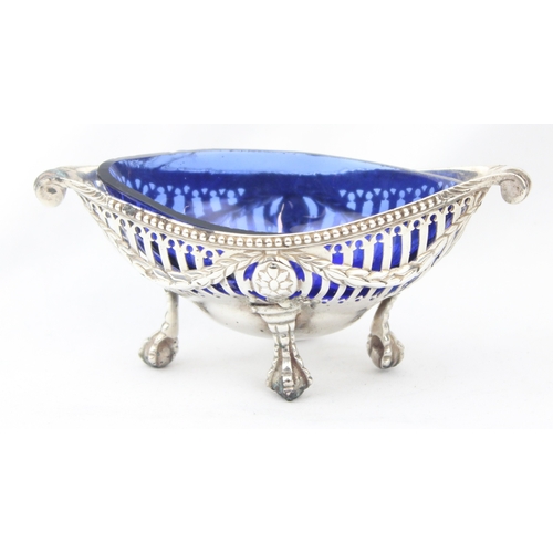 1072 - A George III period silver salt with pierced body, scroll ends and ball and claw feet, blue glass li... 