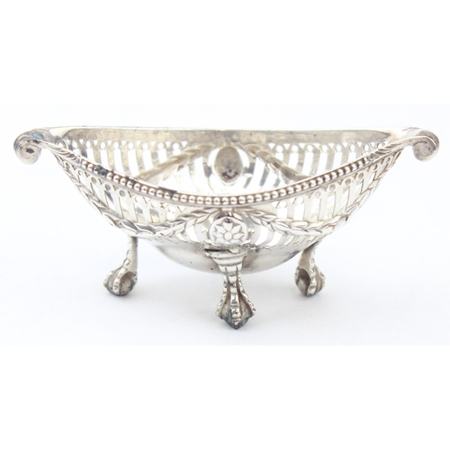 1072 - A George III period silver salt with pierced body, scroll ends and ball and claw feet, blue glass li... 